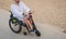 Disabled man in a wheelchair with electric scooter on the beach