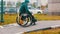 Disabled man in wheelchair makes a successful attempt to steer his wheelchair over a ramp on the street