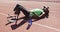 Disabled mixed race man with prosthetic legs lying on race track