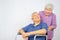 Disabled old man sitting on wheelchair with caring wife on white background, Loving senior couple coping with the husband`s