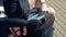 Disabled person with a prosthesis takes his laptop, sitting on a bench.