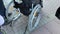 A disabled person sitting in a wheelchair, wheels close up