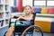 Disabled school girl with books in library