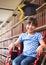 Disabled School girl in education library in wheelchair with graduation hat