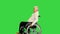 Disabled senior gentleman riding by on a wheelchair on a Green Screen, Chroma Key.