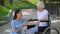 Disabled senior lady in wheelchair talking to volunteer, conversation support