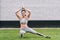 Disabled sportswoman with prosthesis practicing yoga on grass