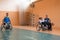 Disabled War veterans mixed race and age basketball teams in wheelchairs playing a training match in a sports gym hall