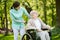 Disabled woman with caregiver in the garden of the nursing home