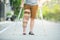 Disabled woman with crutches or walking stick or knee support standing in back side,half  body