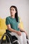 Disabled woman looking away while sitting in wheelchair at home