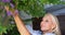 Disabled woman plucking flowers from plant in the porch 4k