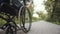 Disabled woman pushes wheelchair wheel with her hand while ride along path in park, front view. Disabled woman pushes