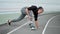 Disabled woman stretching legs at stadium. Girl practicing yoga on sports track