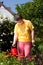 Disabled woman waters flowers in the garden