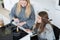 Disabled woman in wheelchair preparing meal with friend in kitchen