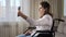 Disabled woman in wheelchair talks on videocall at home