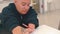 Disabled woman writes pen text on paper at a table in the office.