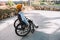 Disabled young girl using wheelchair on street.