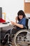 Disabled young girl on wheelchair working in her office