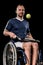 Disabled young sportsman sitting in wheelchair and playing tennis