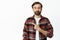 Disappointed adult guy with beard, pointing left and grimacing upset, dislike something, standing over white background