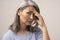 Disappointed Adult Woman of Mongolian Nationality with Gray Hair on a Gray Background.