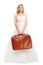 Disappointed bride holding a brown suitcase