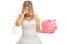 Disappointed bride holding a piggybank