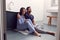 Disappointed Couple Sitting On Floor In Bathroom At Home With Negative Home Pregnancy Test