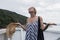 Disappointed female tourist on summer cruss ship vacation, standing on rain and looking angry at overcast cloudy sky