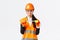 Disappointed gloomy female asian construction engineer, architect showing small size on tape measure, pouting upset with