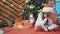 Disappointed little girl wearing Christmas costume sitting in lotos position over wooden christmas background, frowning