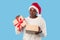 Disappointed Plump Black Woman Holding Bad Xmas Present, Blue Background