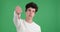 Disapproving Caucasian Man Showing Thumbs Down Gesture on a Green Background