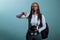 Disapproving photographer giving thumbs down gesture at camera while standing on blue background.