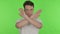 Disapproving Young Man Rejecting by Arm Gesture on Green Background
