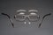 Disassembled metal frame eyeglasses on black surface,lens