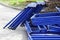 disassembled scaffolding in the form of tubes, painted in blue paint lay beside construction house.