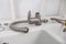 Disassembled water tap and pipe wrench near sink on countertop