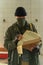 Disaster survivor soldier in a post apocalyptic world, he is wearing a bandana mask and reading documents. Environmental