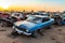 Discarded cars in a vast automotive landfill highlight the issue of environmental pollution caused by end-of-life vehicles. The