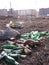 Discarded dirty empty glass bottles beer in a garbage dump near city houses