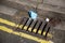 a discarded medical face mask in the street on a drain