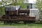 Discarded rusty freight steam locomotive loaded on old wagon.