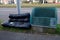 Discarded sofa left beside the garbage bin on footpath.