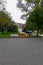 Discarded wooden furniture and an old bed lined up by the curb near a street waiting for trash pickup