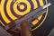 Discharged handgun lying on back of dartboard target. Toned