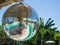 Disco ball reflecting green swimming pool.