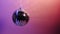 Disco ball spinning on neon purple background. 360 degree rotation. Zero gravity, levitation